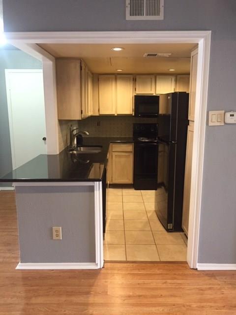 15889 Preston Road, Unit 2062 Dallas, TX 75248 - Photo 1 of 1 a kitchen with granite countertop a refrigerator and a stove