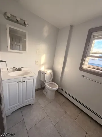 a bathroom with a sink a toilet a window and a mirror