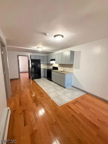 a large white kitchen with wooden floors and stainless steel appliances