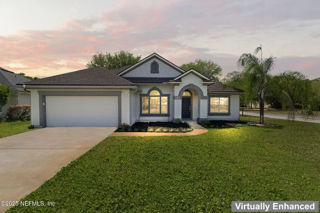 a front view of a house with a yard and garage