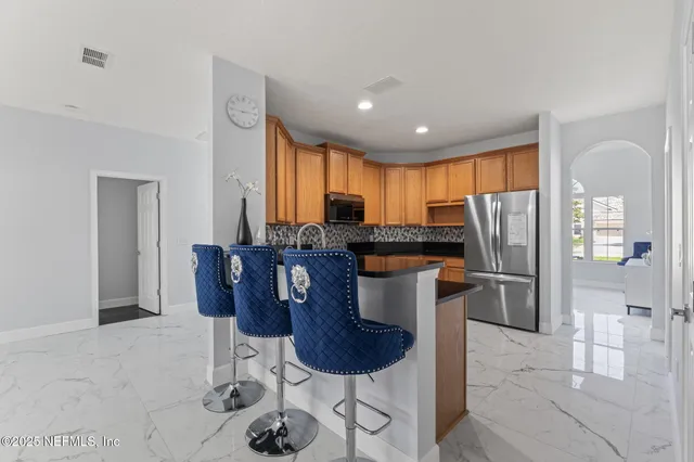 a kitchen with granite countertop a sink stainless steel appliances and cabinets