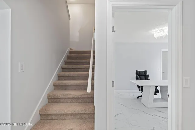 a view of a big room with wooden floor and a chandelier fan