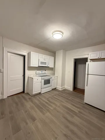 a view of a kitchen with a sink stove refrigerator and empty room