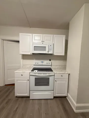a white kitchen with a stove top oven