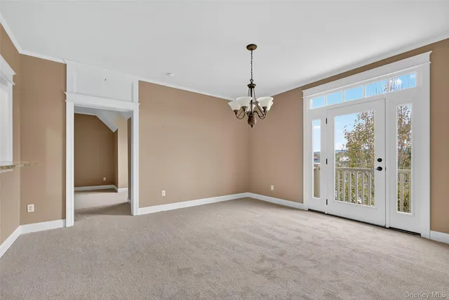 a view of a big room with windows and chandelier fan