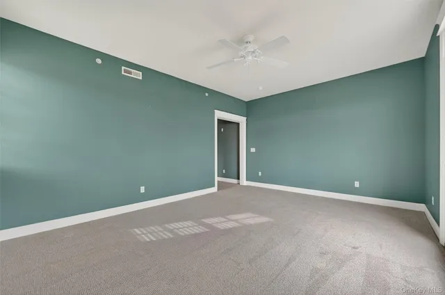 a view of an empty room with a chandelier fan