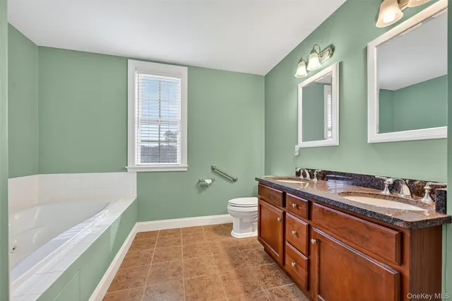 a bathroom with a tub sink and mirror