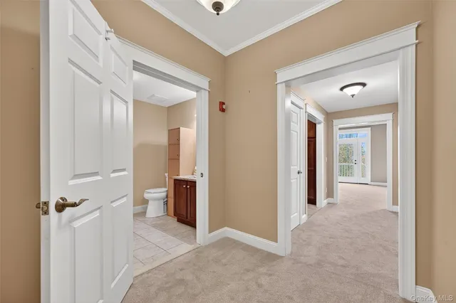 a view of a hallway with closet and a bathroom