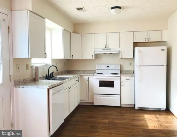 a kitchen with a white cabinets and white appliances