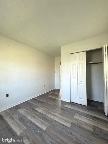 an empty room with wooden floor and closet