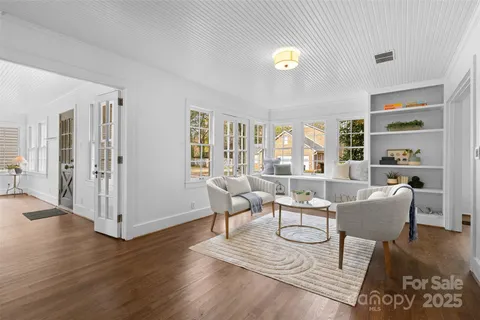 a living room with furniture a desk and chair with wooden floor
