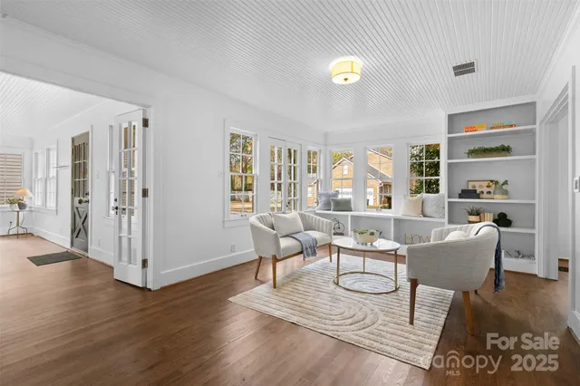 a living room with furniture a desk and chair with wooden floor