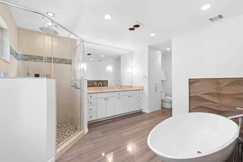 a bathroom with a double vanity sink a mirror and a shower