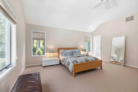 a spacious bedroom with a bed and large windows