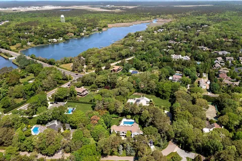 an aerial view of residential houses with outdoor space and trees