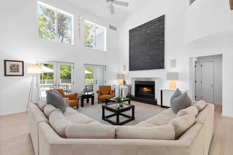 a living room with furniture a fireplace and a large window