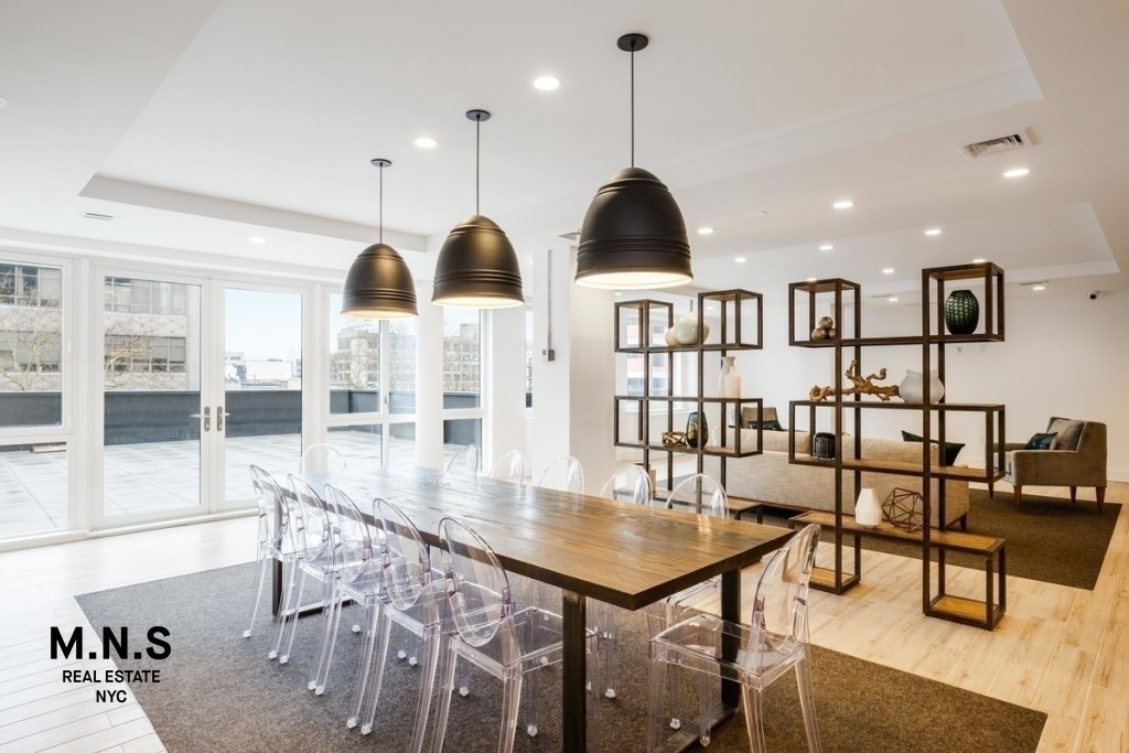 37-14 36th Street, Unit 10F Queens, NY 11101 - Photo 7 of 15 a kitchen with stainless steel appliances kitchen island granite countertop a table chairs and a view of living room