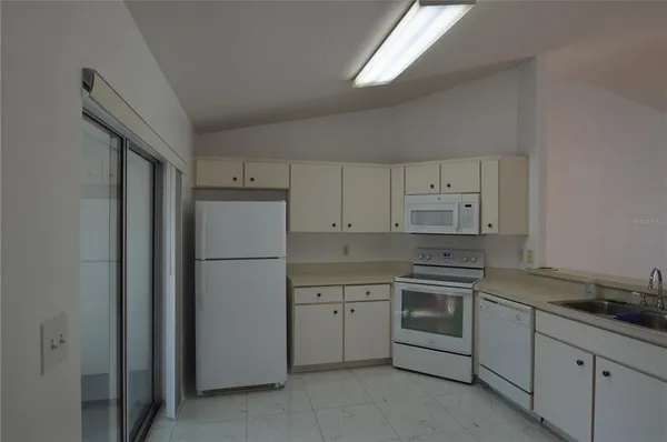 a kitchen with cabinets appliances and a sink