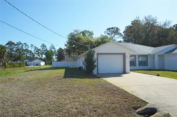 a front view of a house with a yard and trees