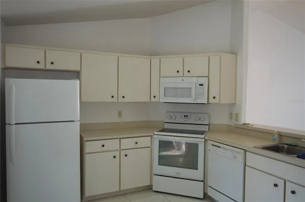 a kitchen with cabinets appliances a sink and a counter space
