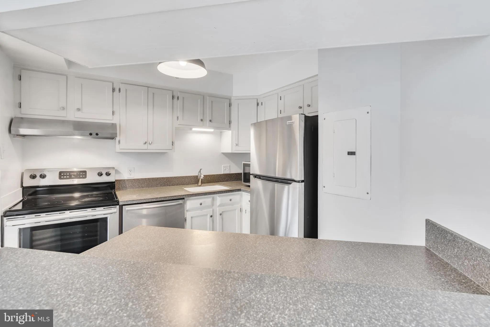 1301 North Courthouse Road, Unit 1007 Arlington, VA 22201 - Photo 13 of 41 a kitchen with granite countertop a refrigerator stove and sink