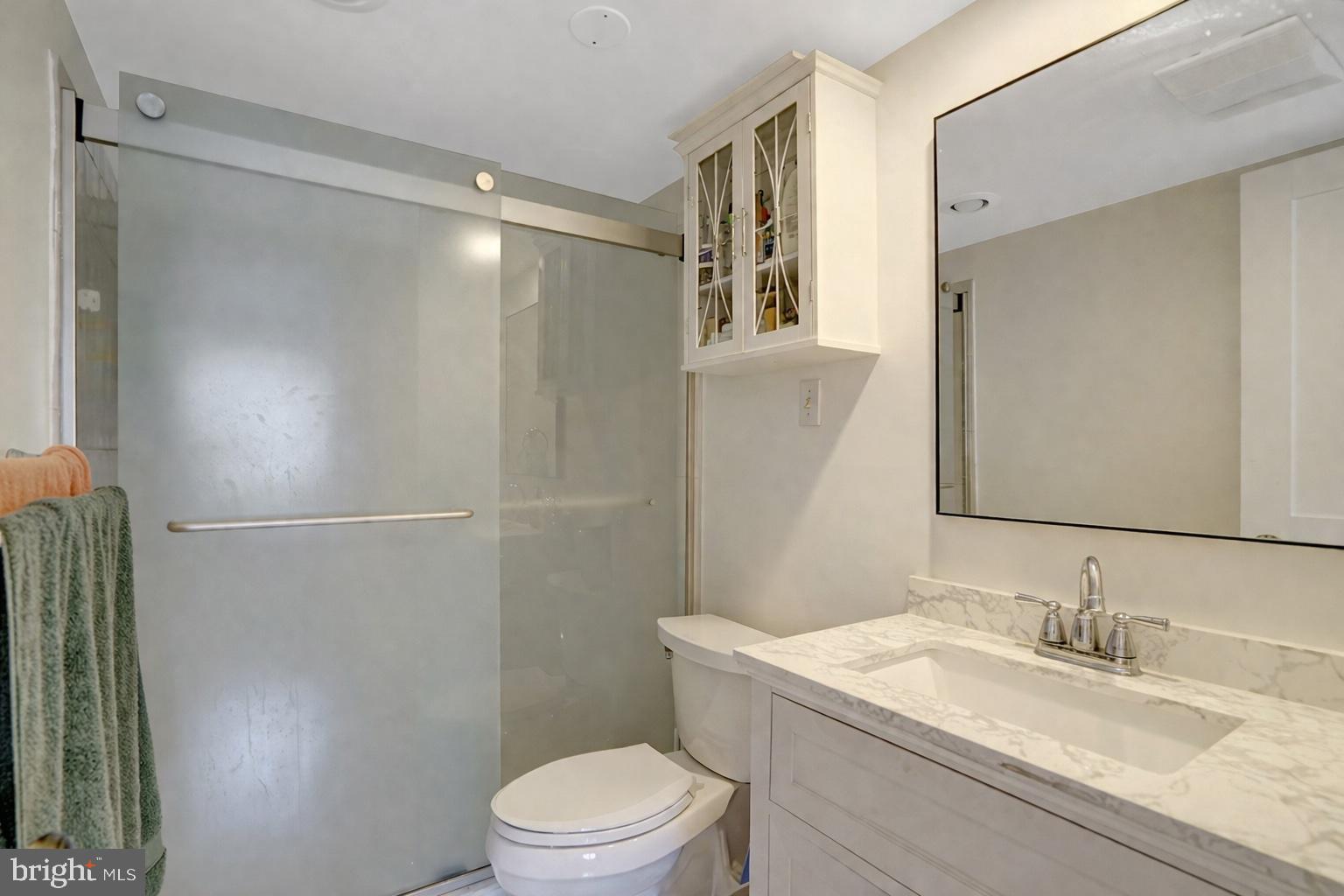 1301 North Courthouse Road, Unit 1007 Arlington, VA 22201 - Photo 18 of 41 a bathroom with a granite countertop sink toilet a mirror and shower