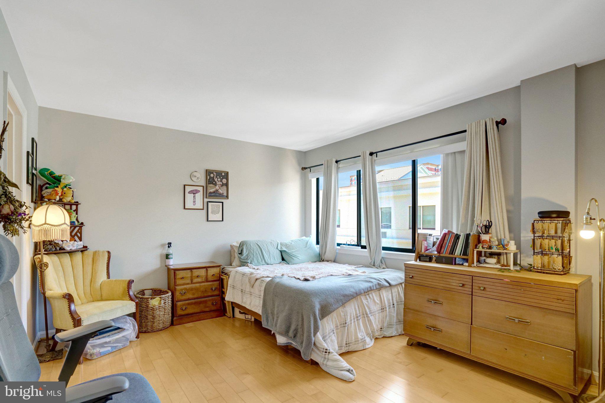 1301 North Courthouse Road, Unit 1007 Arlington, VA 22201 - Photo 27 of 41 a spacious bedroom with a bed a couch and dresser