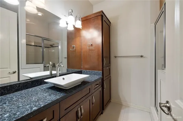 a bathroom with a granite countertop sink and a mirror