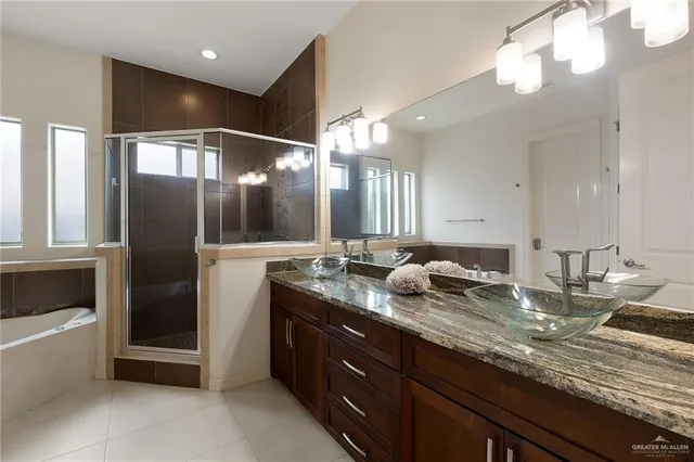 a bathroom with double vanity and a large mirror