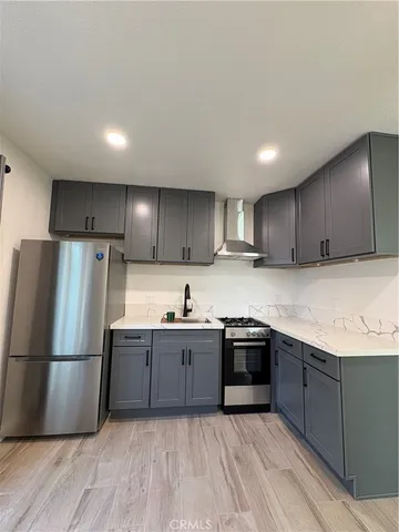 a kitchen with stainless steel appliances granite countertop a sink a stove a refrigerator and cabinets