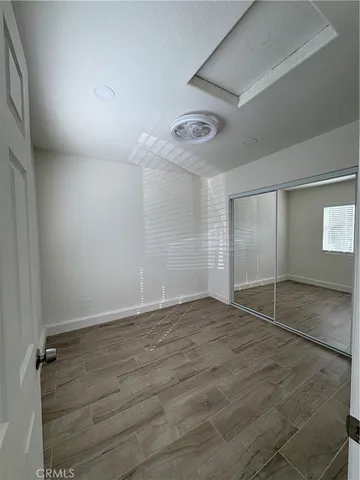 an empty room with wooden floor and closet