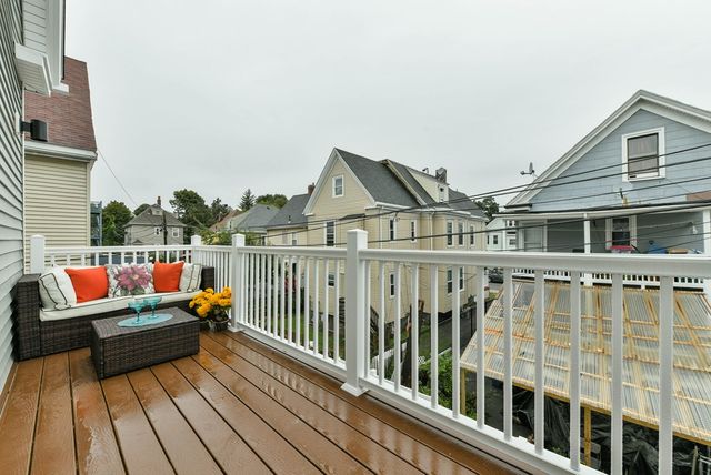 a balcony with wooden floor and city view
