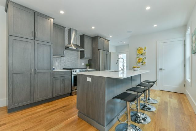 a kitchen with stainless steel appliances granite countertop a refrigerator and a sink