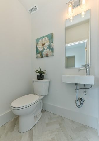 a white toilet sitting next to a bathroom sink
