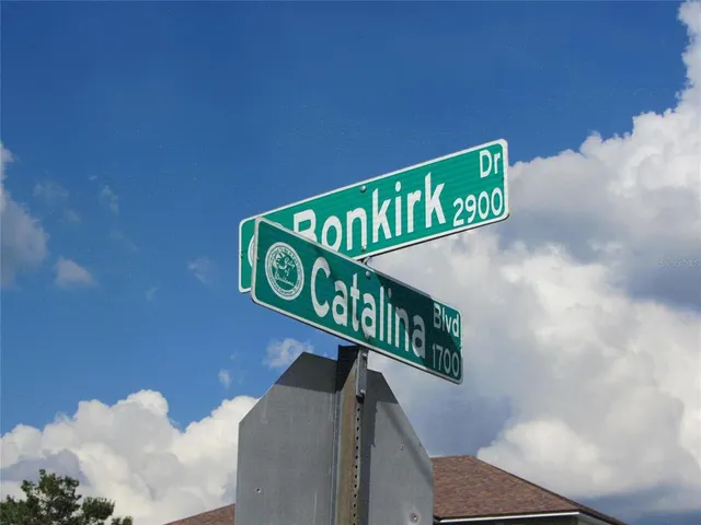 a street sign sitting on a wall next to a road