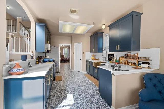 a kitchen with a sink stove cabinets and refrigerator