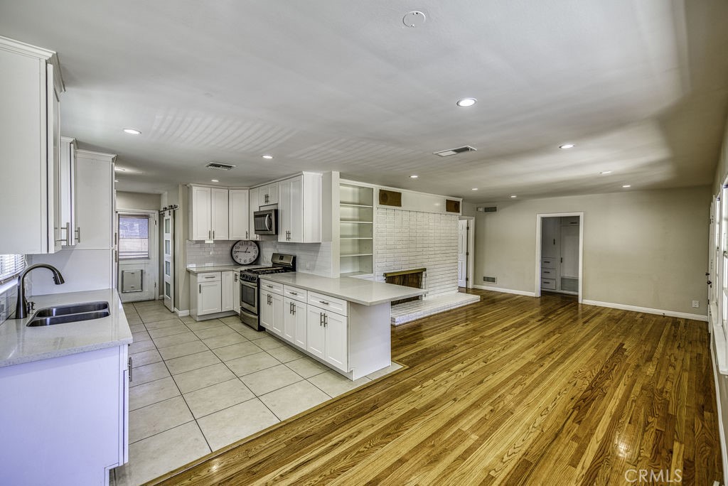 15744 Hart Street Van Nuys, CA 91406 - Photo 5 of 21 a large white kitchen with cabinets stove a sink and dishwasher
