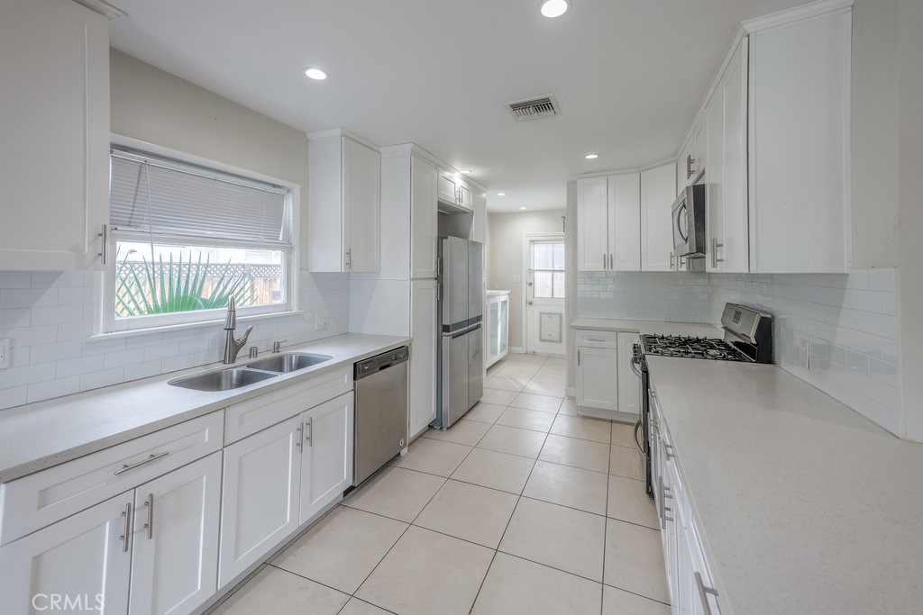15744 Hart Street Van Nuys, CA 91406 - Photo 6 of 21 a large kitchen with a sink and cabinets