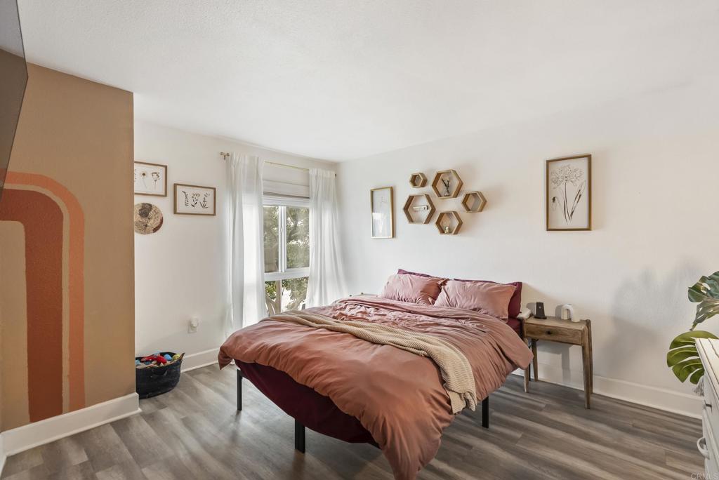 6780 Friars Road, Unit 243 San Diego, CA 92108 - Photo 27 of 31 a bedroom with a bed and wooden floor