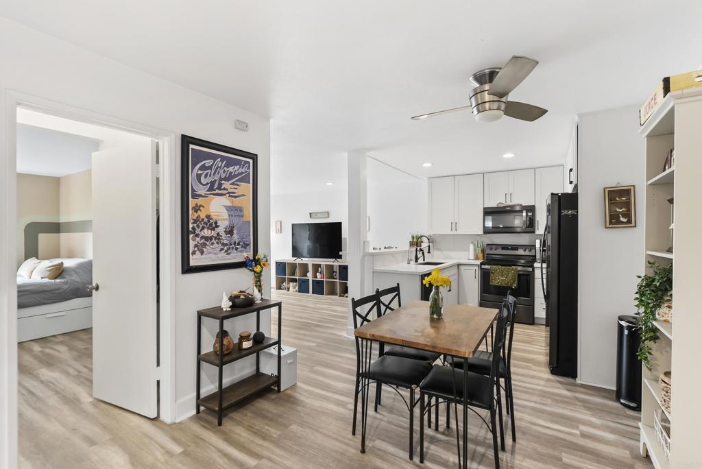 6780 Friars Road, Unit 243 San Diego, CA 92108 - Photo 5 of 31 a view of dining room and livingroom with furniture wooden floor a rug a painting and a chandelier