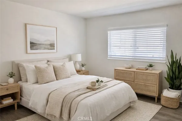 a bedroom with a large bed and a potted plant