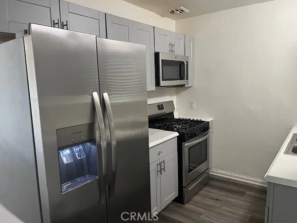 a kitchen with stainless steel appliances granite countertop a refrigerator and a microwave