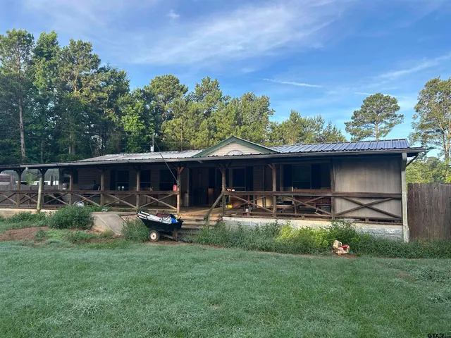 a view of a backyard with table and chairs and potted plants and large tree