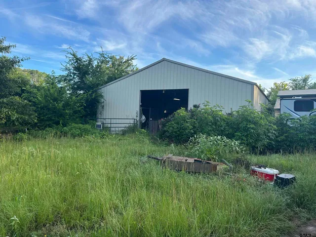 a backyard of a house with plants and wooden fence