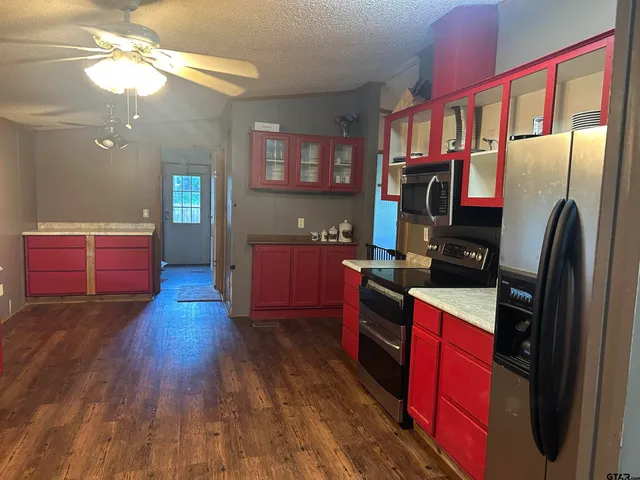 a kitchen with stainless steel appliances granite countertop a refrigerator a stove top oven a sink dishwasher and wooden floor