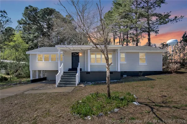 a view of a house with a yard and large tree