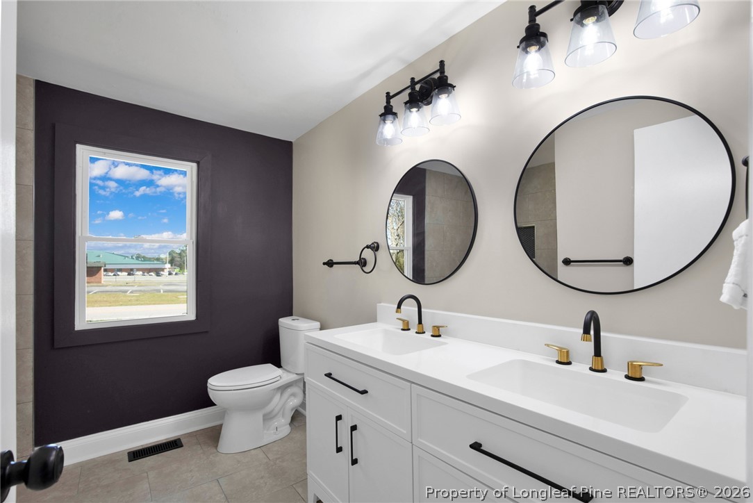 88 Hannah Creek Road Four Oaks, NC 27524 - Photo 26 of 31 a bathroom with a toilet a sink and a mirror