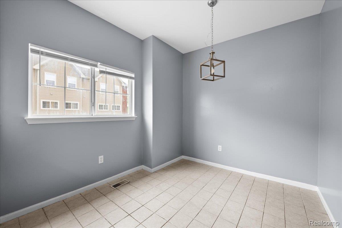 22684 Goddard Road Taylor, MI 48180 - Photo 9 of 29 Room featuring tiled flooring, a prominent window with white trim, and a modern geometric light fixture