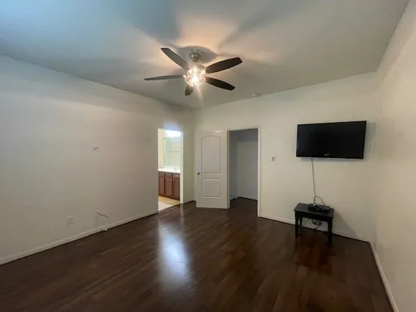 a view of a livingroom with wooden floor and a ceiling fan