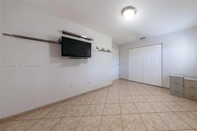 a spacious bedroom with a bed and a dresser